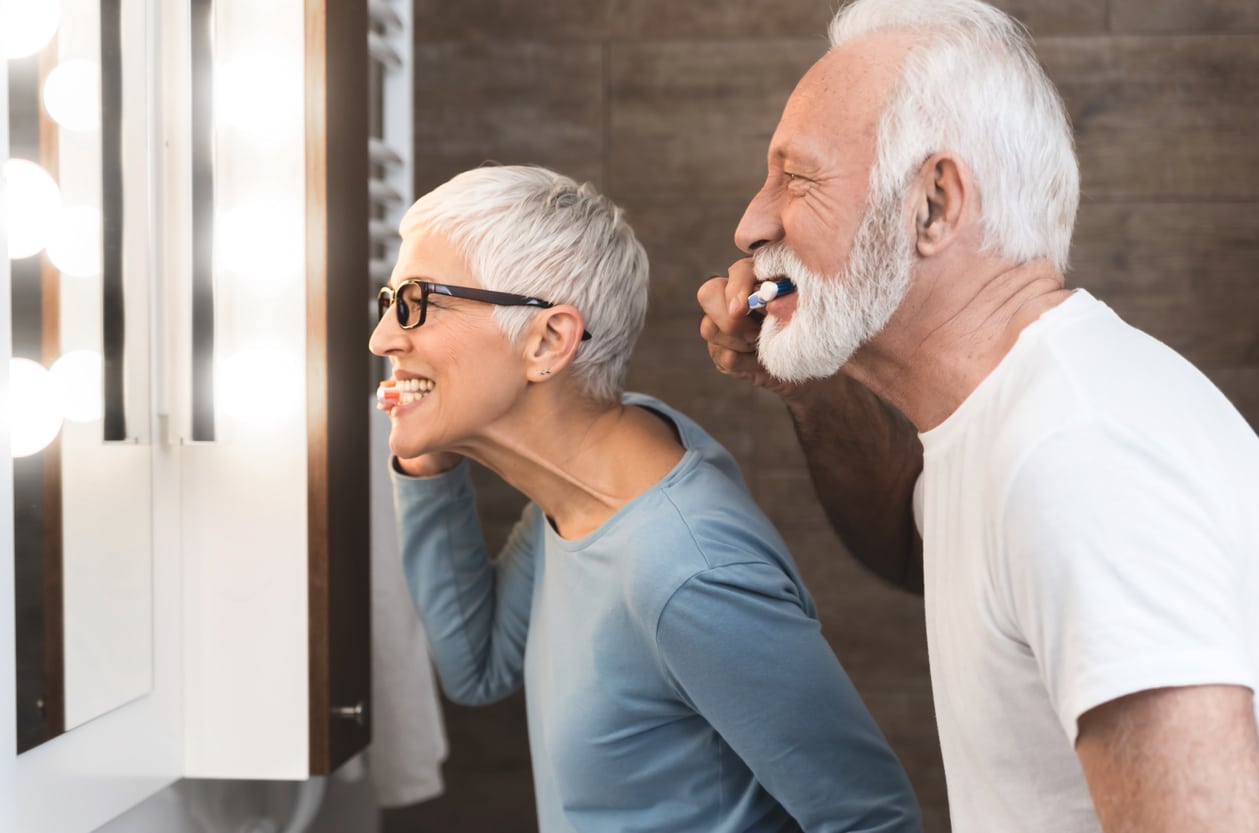 Man and woman brushing teeth