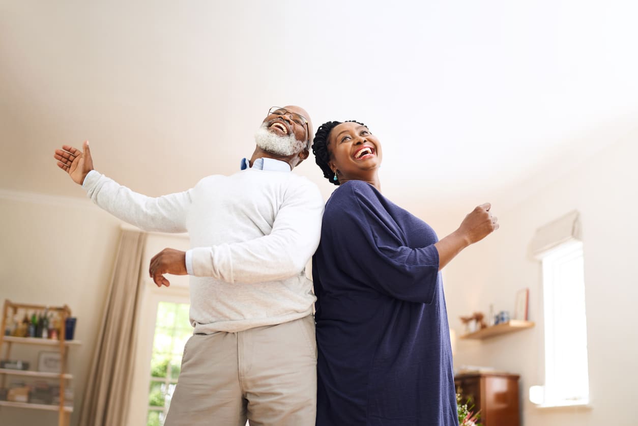 Senior couple dancing together at home